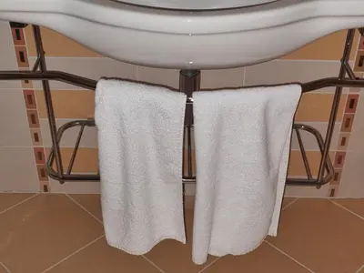 a bathroom with white towels hanging from a sink at Emerald Beach Resort & Spa, Apartment S105 in Ravda