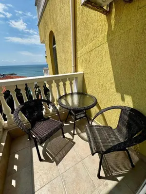 a balcony with a table and chairs and the ocean at Marina Sunrise Complex by the sea in Sveti Vlas