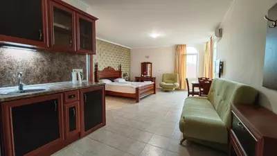 a kitchen and living room with a couch and a bed at Marina Sunrise Complex by the sea in Sveti Vlas