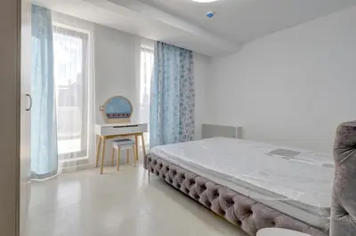 a bedroom with a bed and a desk and a window at Central Luxury One Bedroom in Varna in Varna City