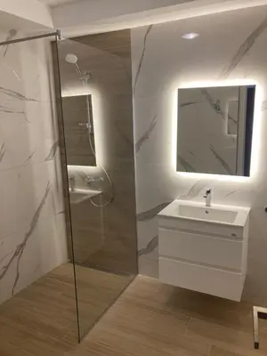 a bathroom with a shower and a sink and a mirror at Central Luxury One Bedroom in Varna in Varna City