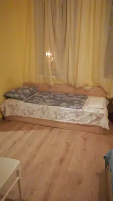 a small bed in a room with a wooden floor at Апартамент 27 юли 1 in Varna City