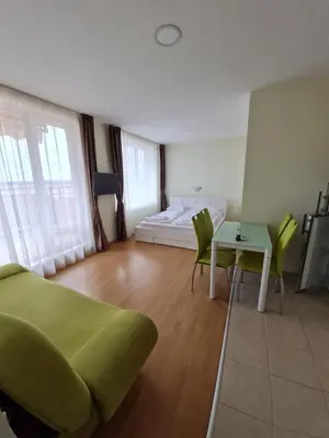 a bedroom with a bed and a table and chairs at Studio in a Resort with 9 pools in Sunny Beach