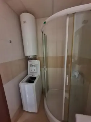 a small bathroom with a washing machine and a shower at Studio in a Resort with 9 pools in Sunny Beach