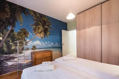 a bedroom with two beds and a mural of a beach at Calm space in Varna top center in Varna City