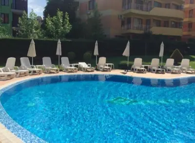 a large blue swimming pool with chairs and umbrellas at Complex-Lesso in Ravda