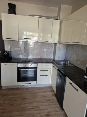 a kitchen with white cabinets and a black appliance at Garden of Eden- MintGarden- Sveti Vlas in Sveti Vlas