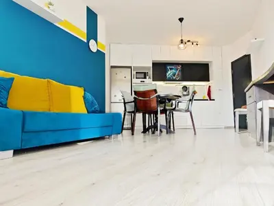 a living room with a blue couch and a table at KJ Apartments - SwimmingPool - 3 Min From the Beach in Burgas City