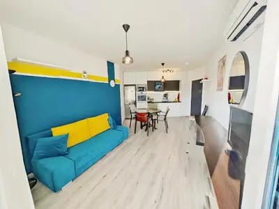 a living room with a blue couch and a table at KJ Apartments - SwimmingPool - 3 Min From the Beach in Burgas City