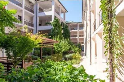 a courtyard of an apartment building with plants at Galqna in Sozopol