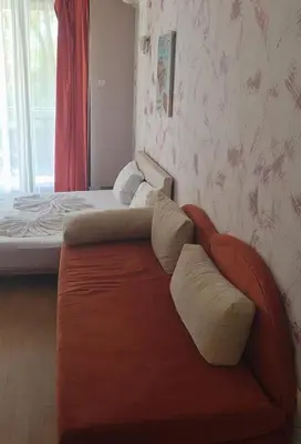 a couch in a room with a bed and a window at Galqna in Sozopol