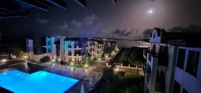 a view of a building at night with a swimming pool at Апартаменти Литорал in Chernomorets