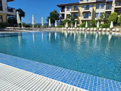 a swimming pool with blue tiles in front of a building at Апартаменти Литорал in Chernomorets