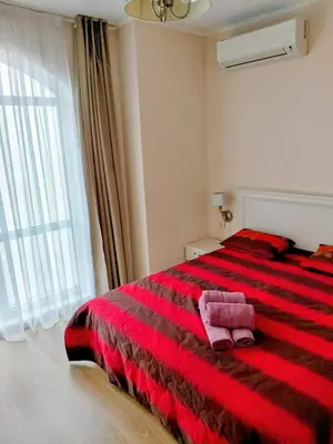 a red bed in a white room with a window at Izida Palace Garden SPA Oasis in Bŭnzareto