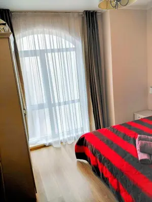 a bedroom with a red and black bed and a window at Izida Palace Garden SPA Oasis in Bŭnzareto