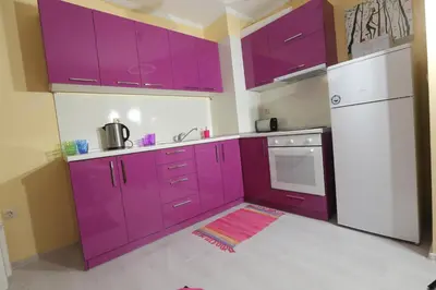 a kitchen with purple cabinets and a white refrigerator at South Beach Apartments in Obzor