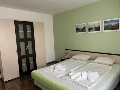 a bedroom with a bed with white sheets and pillows at kaLe in Ravda