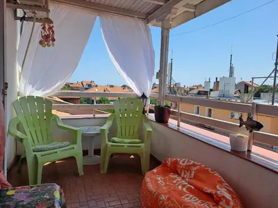 two chairs and a table on a balcony with a view at Панорама in Pomorie