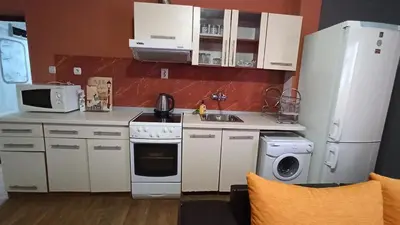 a kitchen with a white refrigerator and a microwave at Панорама in Pomorie