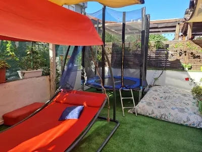 a porch with a swing and a bed and a tent at Панорама in Pomorie