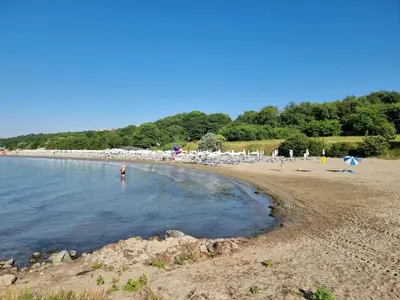 a beach with a group of people in the water at Polonia - KEMNI in Burgas City