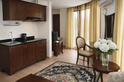 a kitchen and living room with a vase of flowers on a table at Luxury Studio in Sunny Beach with Pool, 5 Mins Walk to Beach in Sunny Beach