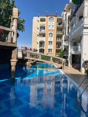 a swimming pool with a bridge and some buildings at Cozy studio in Sanny Beach in Sunny Beach