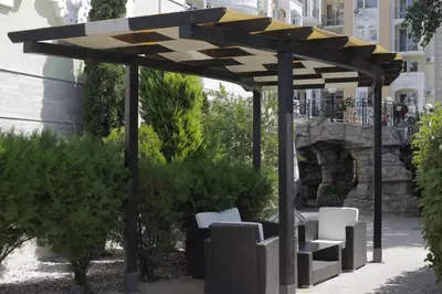 a wooden pavilion with white chairs under it at Cozy studio in Sanny Beach in Sunny Beach