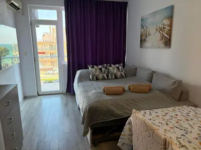 a bedroom with a bed and a large window at Soleil Bleu in Nesebar