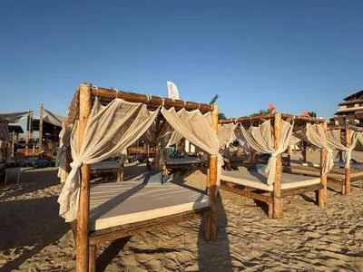 a row of wooden beds on the beach at Soleil Bleu Beachfront Getaway in Nesebar