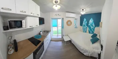 a small bedroom with a bed and a desk in it at Bit of sea in Varna City