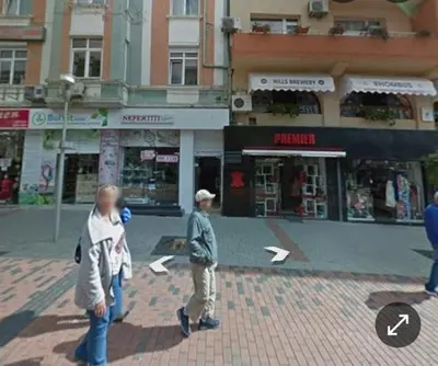 two people walking down a street in a city at Bit of sea in Varna City