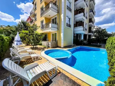 a hotel with a swimming pool and lounge chairs at Magnolia 3 - Menada Apartments in Sunny Beach