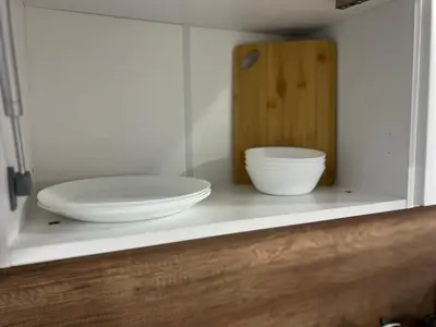 a shelf with two white bowls and a wooden cutting board at Varna Central Seaside Suite in Varna City
