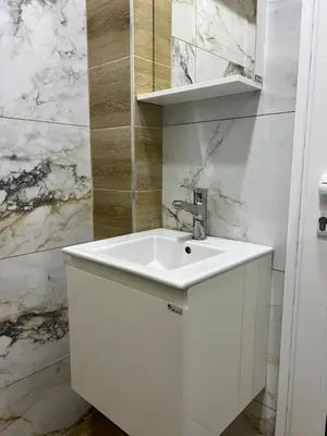 a white sink in a bathroom with marble walls at Varna Central Seaside Suite in Varna City
