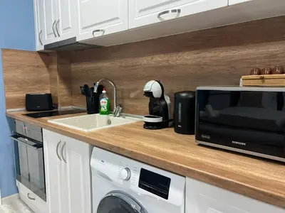 a kitchen counter with a microwave and a sink at Varna Central Seaside Suite in Varna City