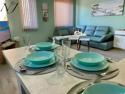 a table with plates and glasses on top of it at NJ Collection in Varna City