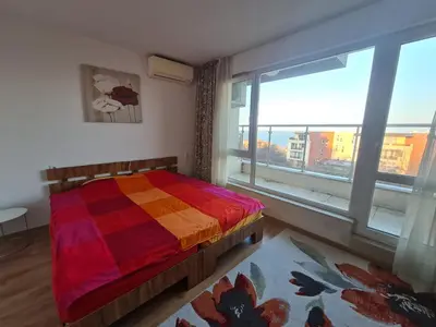 a bedroom with a colorful bed and a large window at Large Two Floor Apartment in Byala