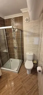 a bathroom with a toilet and a glass shower at East Beach Marina View Apartment in Sveti Vlas