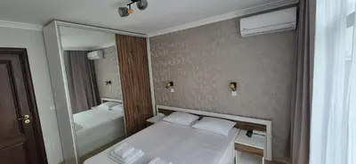 a small bedroom with a bed and a mirror at East Beach Marina View Apartment in Sveti Vlas