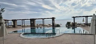 a large swimming pool with the ocean in the background at East Beach Marina View Apartment in Sveti Vlas