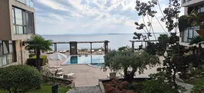 a view of a swimming pool and the ocean at East Beach Marina View Apartment in Sveti Vlas