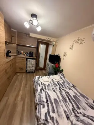 a living room with a bed and a kitchen at Студио-Джени in Burgas City
