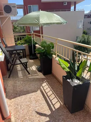 a patio with a chair and an umbrella on a balcony at Nessebar Fort Club in Sunny Beach