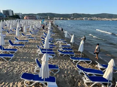 a row of chairs and umbrellas on a beach at Nessebar Fort Club in Sunny Beach