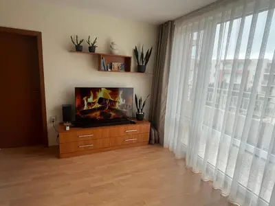 a living room with a tv and a large window at Nessebar Fort Club in Sunny Beach
