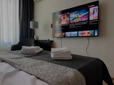 a hotel room with a bed with a flat screen tv on the wall at Слънчев Бряг Какао с басейн плаж in Sunny Beach