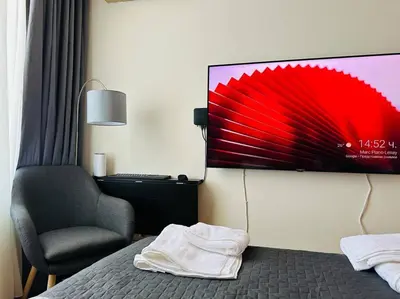 a hotel room with a bed and a chair and a monitor at Слънчев Бряг Какао с басейн плаж in Sunny Beach