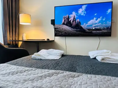 a bedroom with a bed with a flat screen tv on the wall at Слънчев Бряг Какао с басейн плаж in Sunny Beach