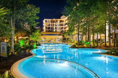 a swimming pool in front of a hotel at night at Harmony Suites Grand Resort-15 Private Apartment in Sunny Beach